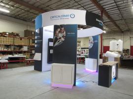 Custom Island Exhibit with Custom Backlit Reception Counter and Pedestal, Monitor Mounts, Cubbies, Literature Trays, Closet Storage, and Round Aero Sign